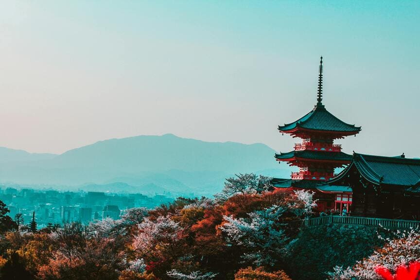 Historic Kyoto temple framed by vivid autumn foliage in November